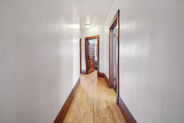 corridor featuring light wood-style floors and baseboards