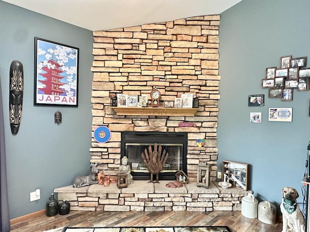 living room with lofted ceiling, baseboards, a fireplace, and wood finished floors