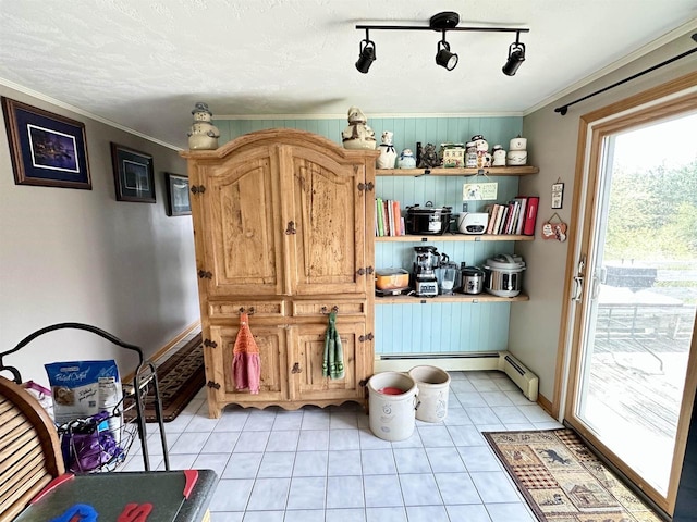 interior space with ornamental molding, a baseboard radiator, light tile patterned floors, and baseboards