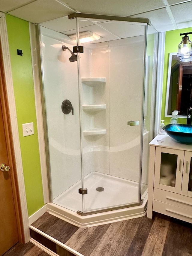 full bathroom featuring vanity, a shower stall, and wood finished floors
