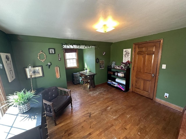 interior space with baseboards, a textured ceiling, and wood finished floors