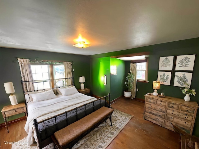 bedroom featuring baseboards and wood finished floors