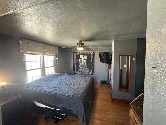 bedroom featuring a textured ceiling, a ceiling fan, and wood finished floors