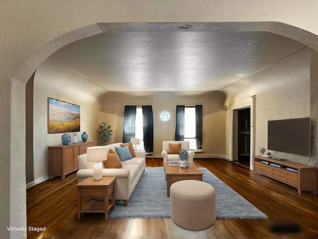 living room with arched walkways and wood finished floors