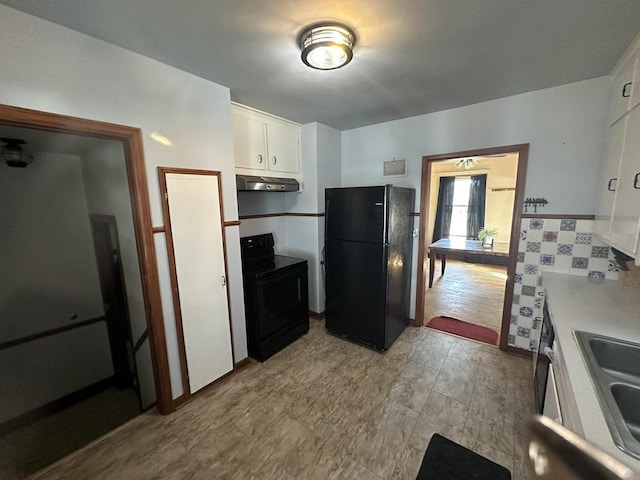 kitchen with under cabinet range hood, a sink, black appliances, light countertops, and white cabinets