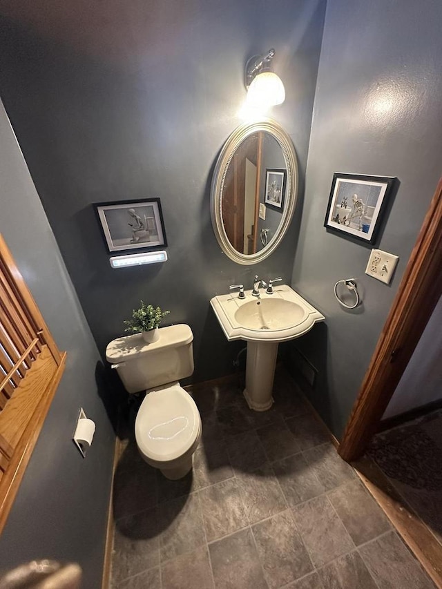 bathroom featuring toilet and baseboards