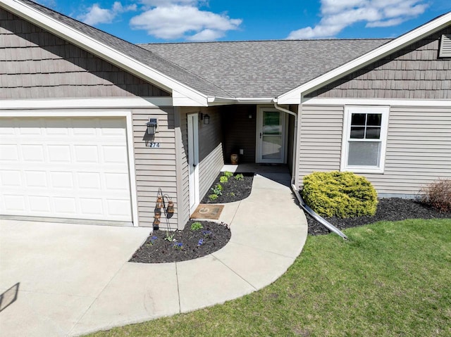 view of exterior entry featuring an attached garage, a shingled roof, and a lawn