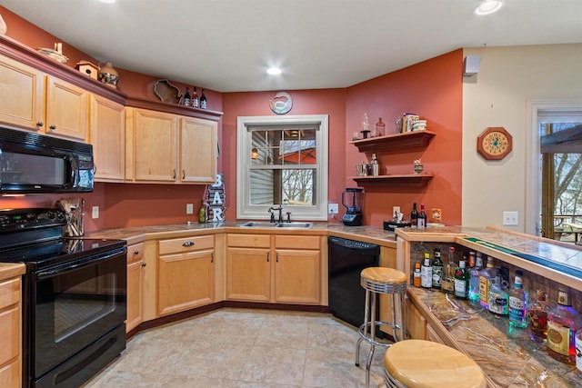 kitchen with a sink, light brown cabinetry, black appliances, and recessed lighting