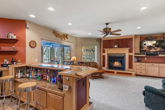 bar with a dry bar, recessed lighting, ceiling fan, a fireplace, and light colored carpet