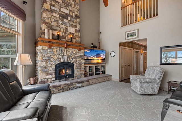 living area featuring plenty of natural light, a fireplace, and a high ceiling