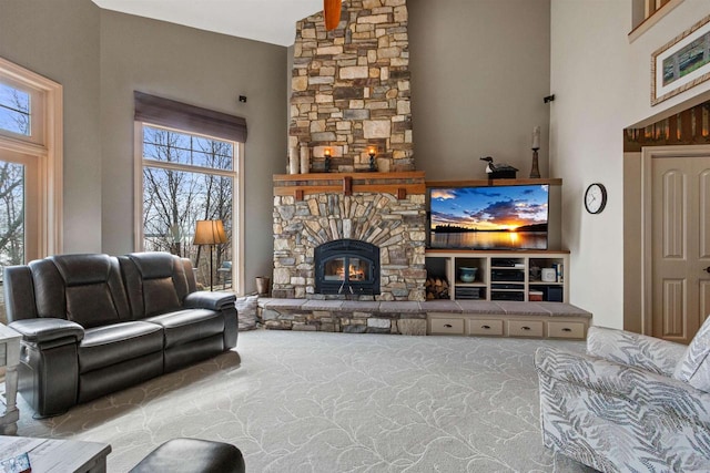 carpeted living room with a wealth of natural light, a fireplace, and high vaulted ceiling