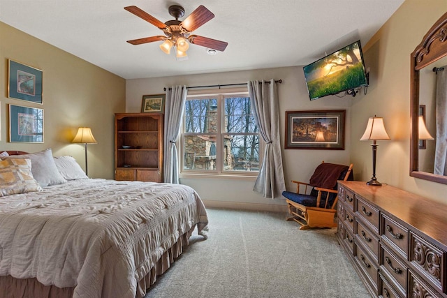 bedroom featuring light carpet, baseboards, and a ceiling fan