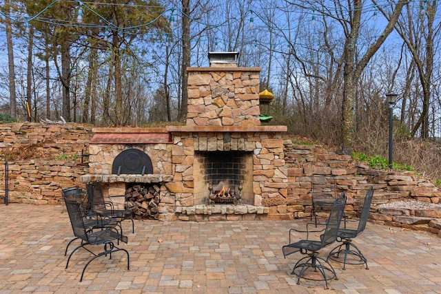 view of patio featuring an outdoor stone fireplace