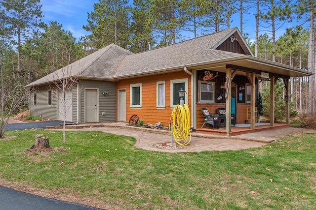 view of front of home featuring a front lawn and roof with shingles