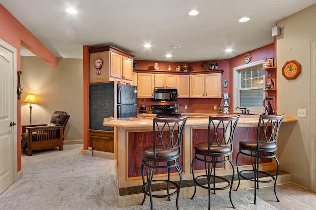 kitchen with black appliances, a peninsula, recessed lighting, and a breakfast bar