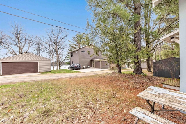 view of yard with an outbuilding, a water view, and a garage