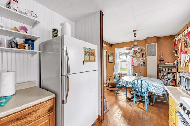 kitchen with pendant lighting, white appliances, light wood finished floors, open shelves, and light countertops