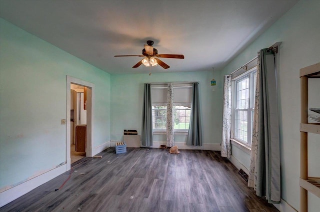 empty room featuring baseboards, a ceiling fan, and wood finished floors