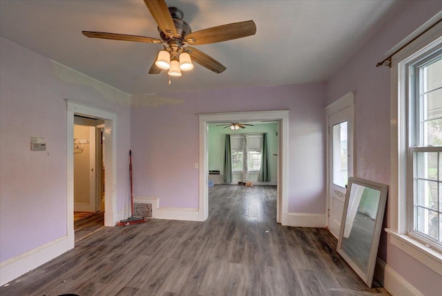 empty room with baseboards, ceiling fan, and wood finished floors