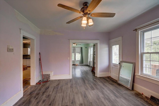 interior space with a ceiling fan, baseboards, visible vents, and wood finished floors
