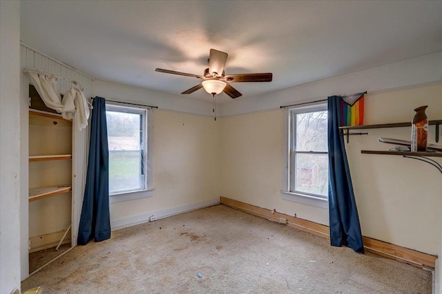 unfurnished bedroom featuring carpet floors, baseboards, and multiple windows