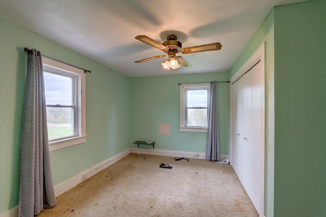 unfurnished bedroom with carpet floors, a closet, and multiple windows