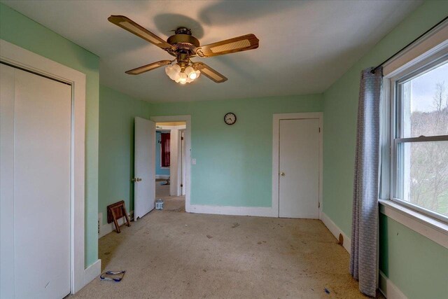 unfurnished bedroom with baseboards, carpet flooring, a closet, and ceiling fan