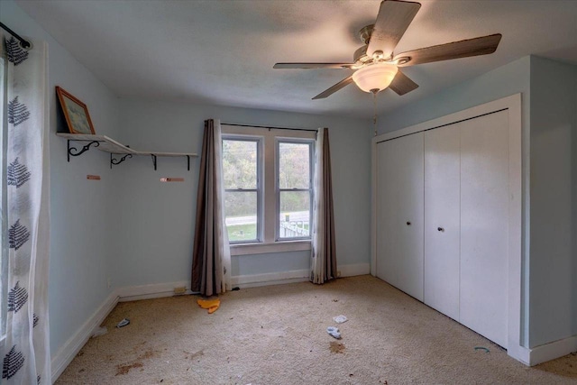 unfurnished bedroom with baseboards, carpet flooring, and a closet