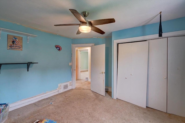 unfurnished bedroom featuring carpet, a closet, a ceiling fan, and visible vents
