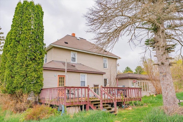 rear view of house with a chimney and a wooden deck