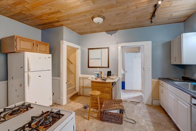 kitchen featuring rail lighting, white appliances, a sink, and wood ceiling