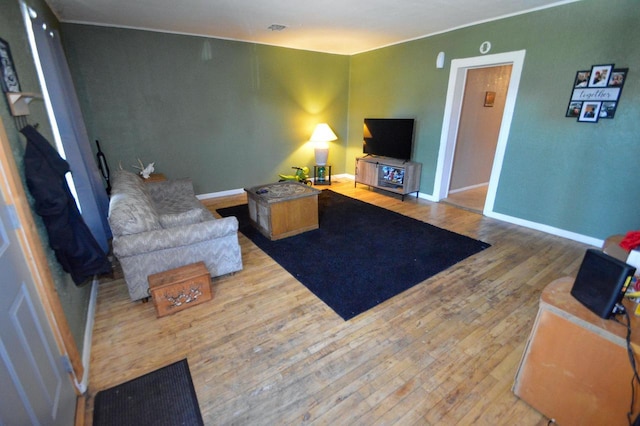 living room featuring baseboards, visible vents, and wood finished floors
