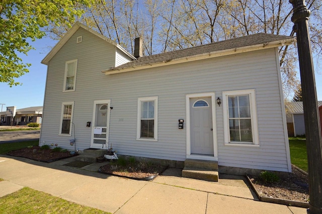 view of front of house with a chimney and entry steps