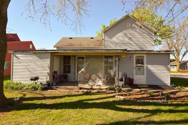 back of property featuring a lawn and a shingled roof