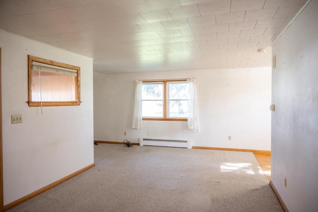 carpeted empty room featuring baseboards and a baseboard heating unit