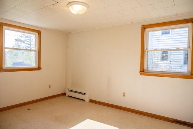 unfurnished room with a wealth of natural light, baseboards, and a baseboard radiator