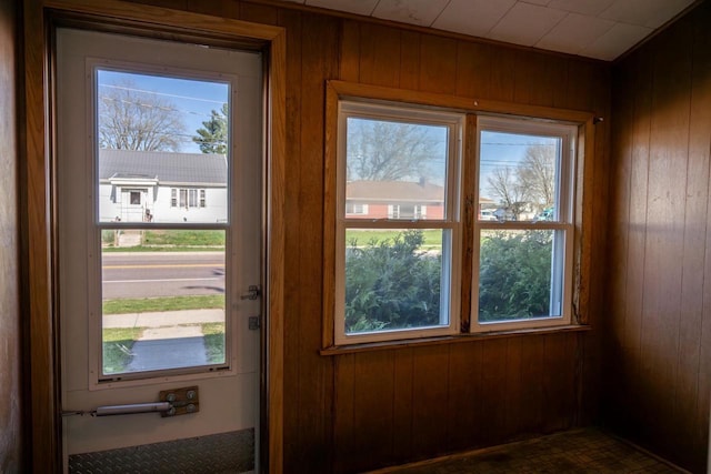 doorway to outside featuring wood walls