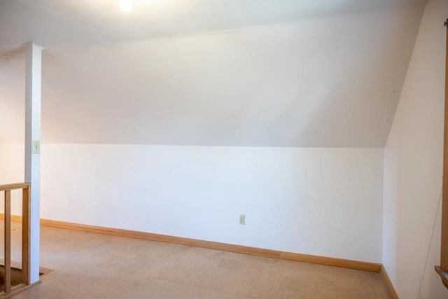 additional living space with baseboards and lofted ceiling