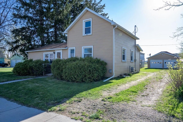view of front facade featuring an outdoor structure, a front lawn, and a detached garage