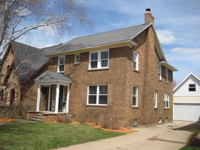 view of side of property with a chimney, an outbuilding, brick siding, a garage, and concrete driveway