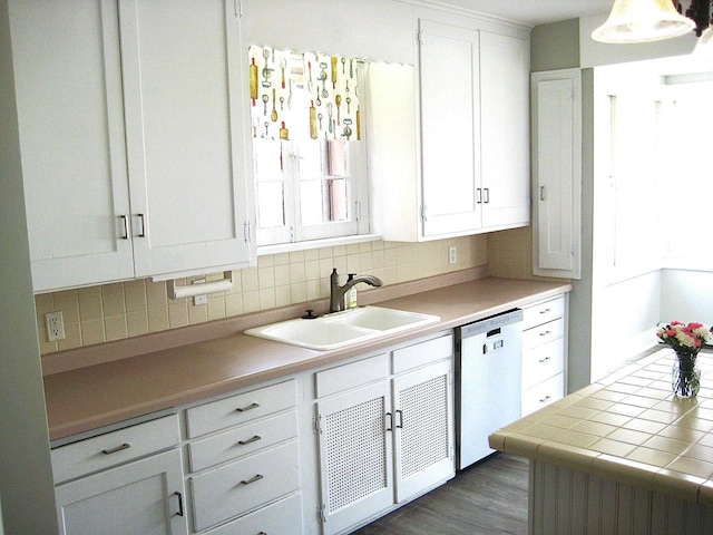 kitchen with white cabinets, dishwasher, backsplash, and a sink
