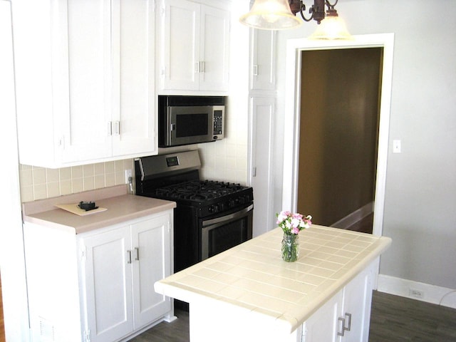 kitchen featuring tile countertops, stainless steel appliances, and white cabinetry