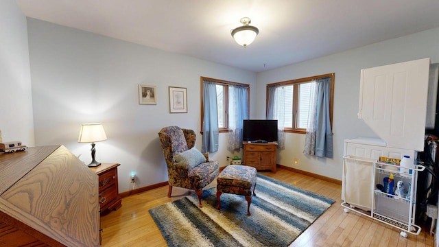 sitting room with baseboards and light wood-style flooring