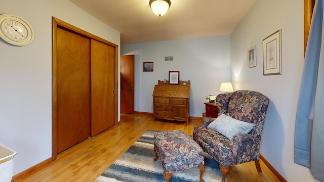 living area with light wood-style flooring, baseboards, and visible vents
