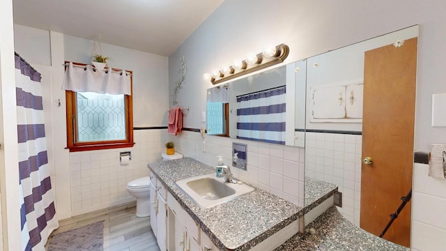 bathroom featuring vanity, tile walls, a shower with curtain, and toilet