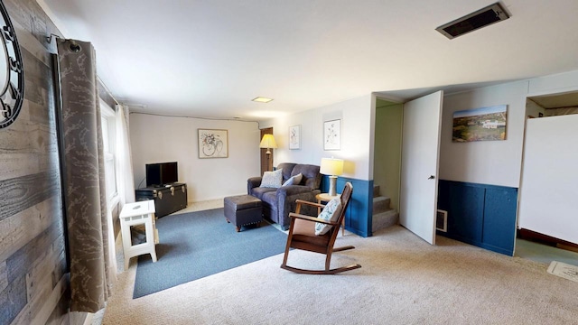 carpeted living room featuring stairs and visible vents