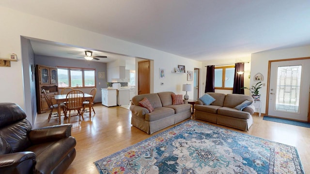 living area with a ceiling fan and light wood-style floors
