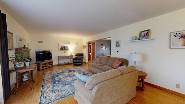 living area featuring baseboards, visible vents, and wood finished floors