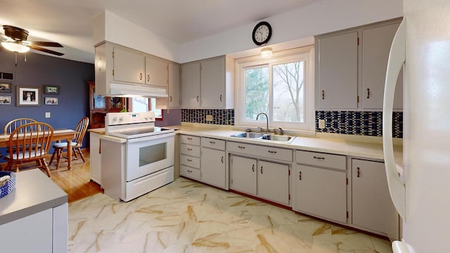 kitchen featuring under cabinet range hood, white appliances, ceiling fan, a sink, and tasteful backsplash