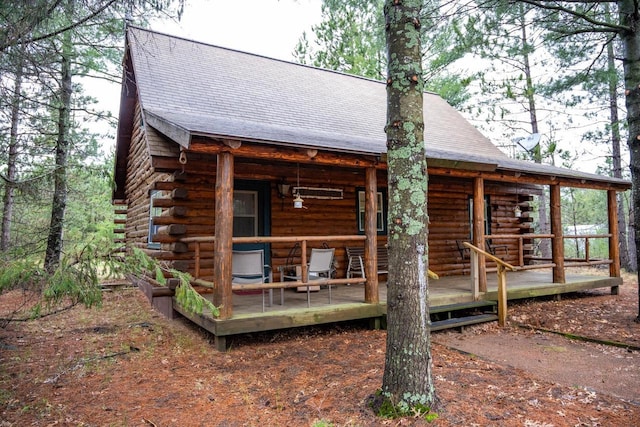 exterior space featuring roof with shingles and log exterior
